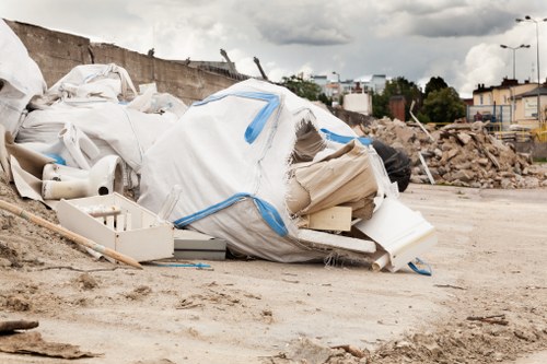 Construction workers using a skip for waste disposal